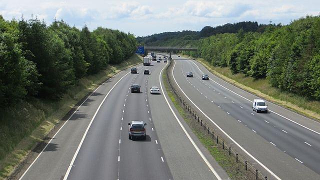 The A74(M) motorway in the south of Scotland with a number of cars and lorries travelling along it