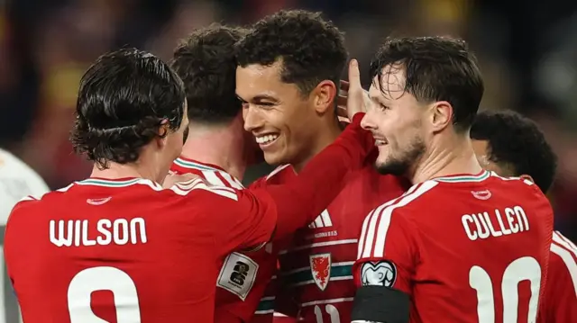 Liam Cullen (right) celebrates with Wales team-mates against North Macedonia