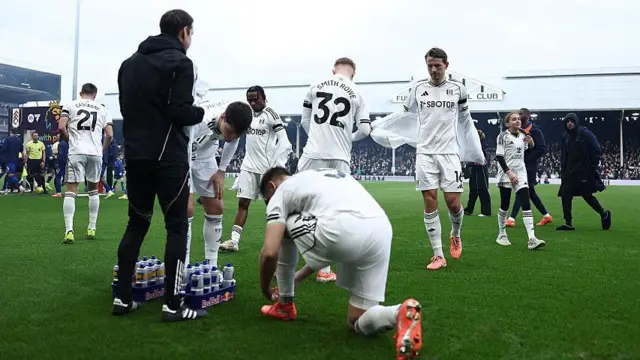 Fulham players gather on the pitch before a match at Craven Cottage