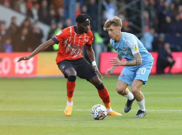 Jack Clarke of Sunderland is challenged by Elijah Adebayo of Luton during the Championship Play-Off Semi-Final Second Leg match between Luton Town and Sunderland at Kenilworth Road on May 16, 2023