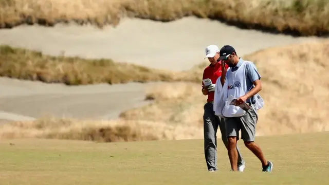 Jordan Spieth walks with his caddie