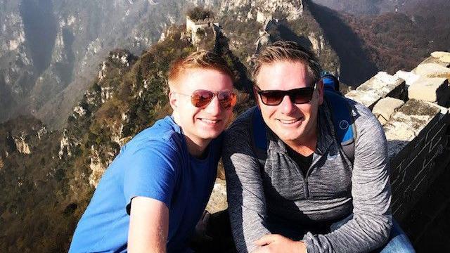 Sam Hall and his dad Chris sitting on the Great Wall of China