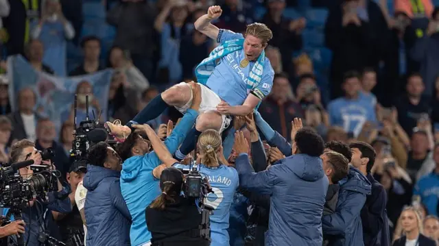 Kevin De Bruyne is thrown in to the air by team mates