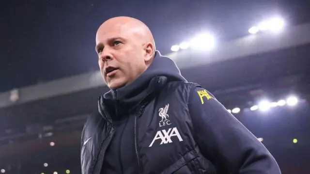 Arne Slot walks under the lights are Anfield