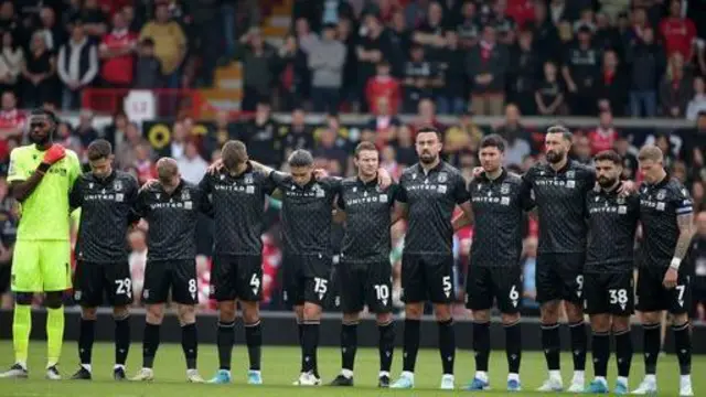 Wrexham's players stand in a minute's silence for the Gresford disaster