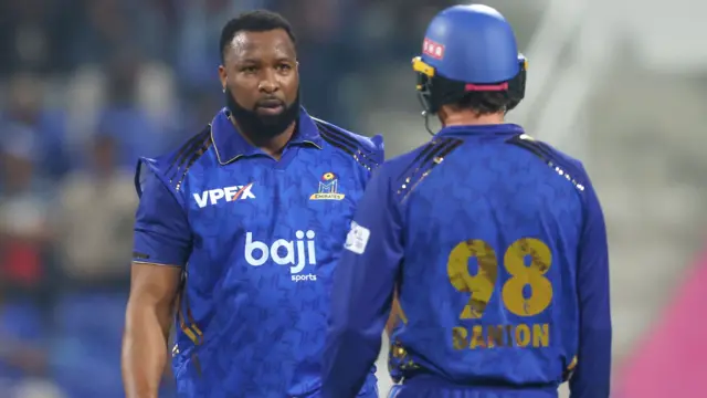 Kieron Pollard and Tom Banton of MI Emirates speak in the middle of the wicket