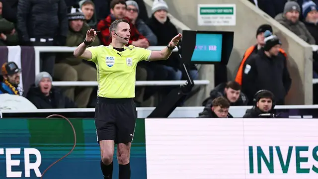 Referee Chris Kavanagh indicates the VAR decision