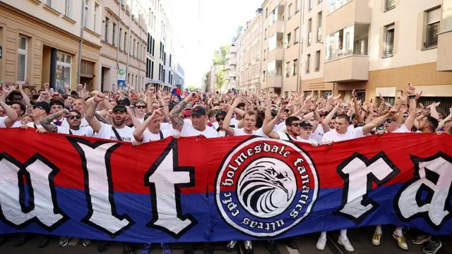Crystal Palace fans march behind a banner in Leipzig