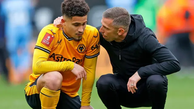 Wolves manager Gary O'Neil crouches and puts his arm around Joao Gomes