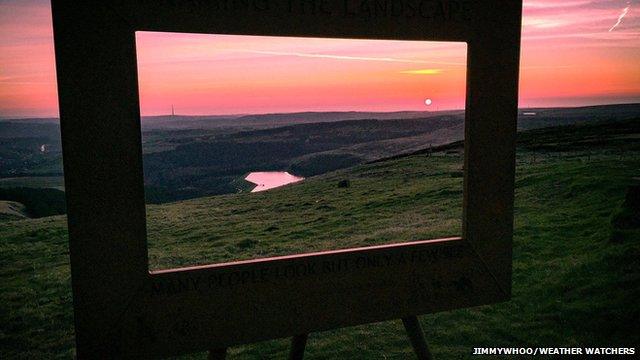 A sunrise through a frame sculpture