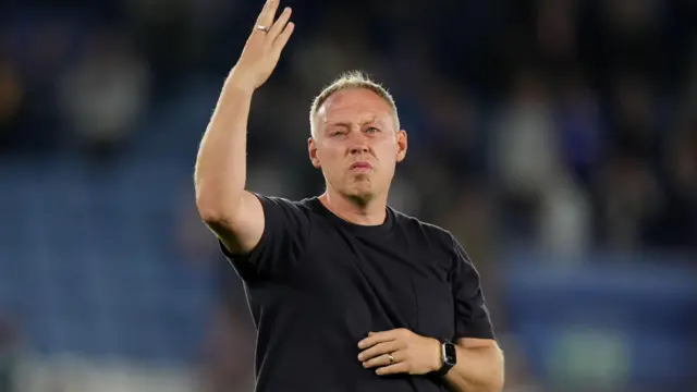 Steve Cooper waves at the travelling fans from the pitch