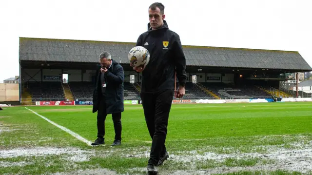 Referee Don Robertson calls the match off during a secondary pitch inspection ahead of a cinch Premiership match between Dundee and Rangers at the Scot Foam Stadium at Dens Park, on April 10, 2024, in Dundee, Scotland.