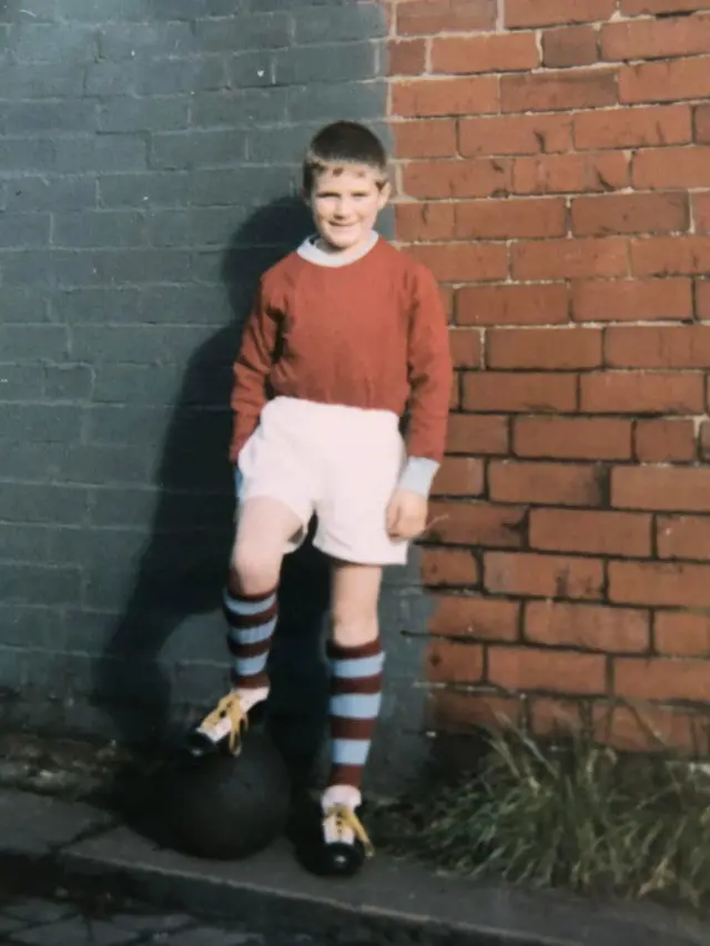 Young Burnley supporter dressed in a Burnley kit.