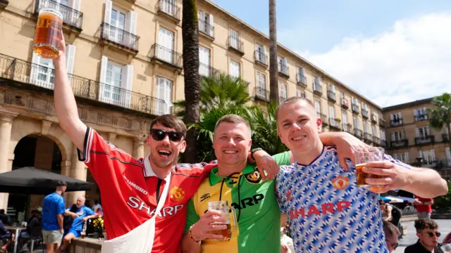 Three Manchester United fans posing for a picture
