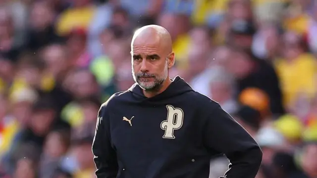 Pep Guardiola looks on from touchline
