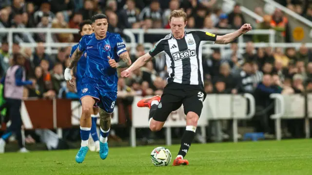 Sean Longstaff on the ball, chased by Enzo Fernandez