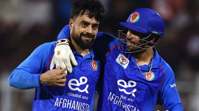 Rashid Khan is embraced by a team-mate while playing for Afghanistan