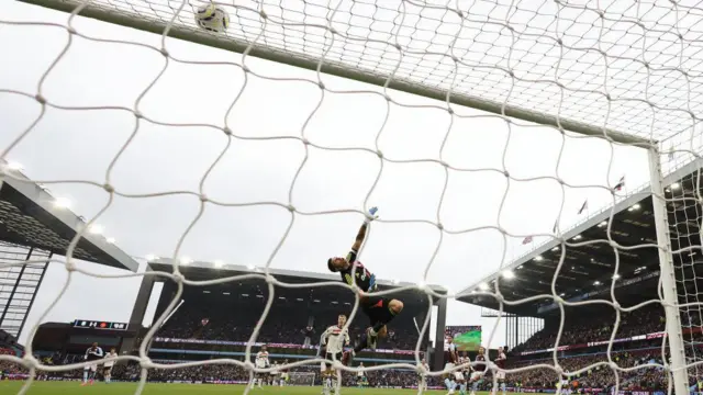 Aston Villa goalkeeper Emiliano Martinez dives to make a save