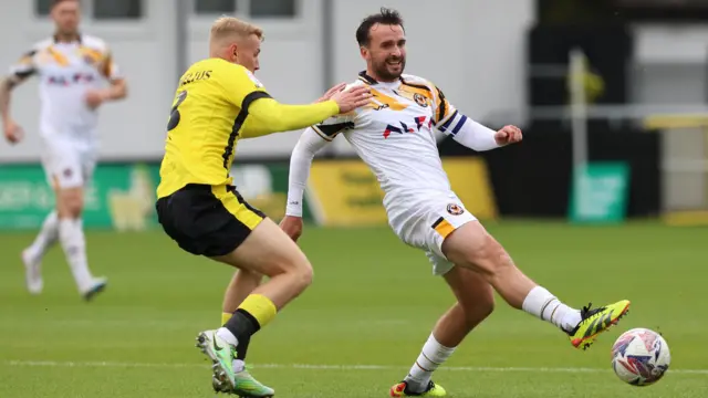 Aaron Wildig of Newport County (R) and Dean Cornelius of Harrogate Town battle for the ball