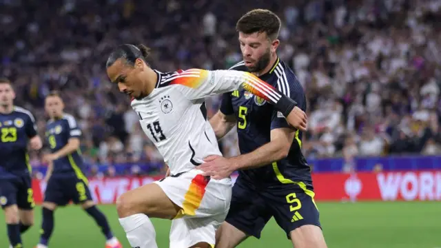 Leroy Sane of Germany (L) and Grant Hanley of Scotland