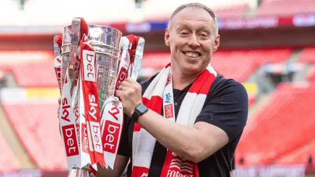 Steve Cooper holds the Championship play-off trophy after winning promotion with Nottingham Forest. 