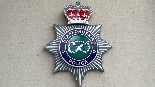 A sign at the headquarters of Staffordshire Police showing the police force's emblem against a white background.