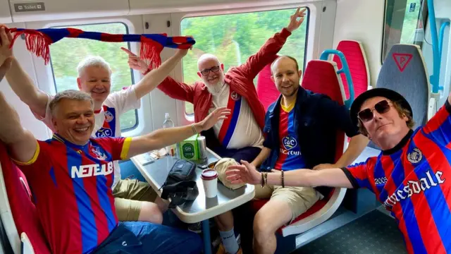 A group of five men dressed in Crystal Palace attire
