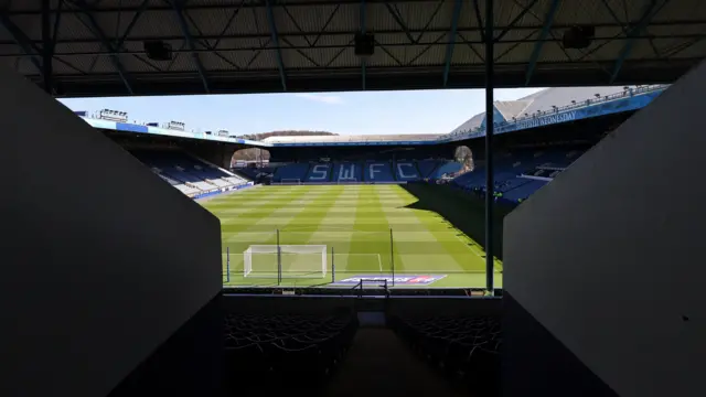 Sheffield Wednesday's Hillsborough stadium from an entrance tunnel to the stadium, with sunlight shining over the stadium
