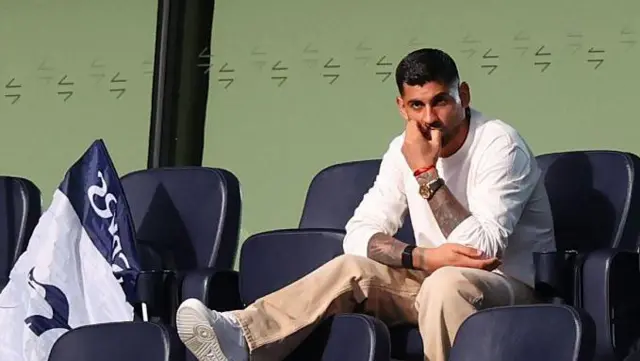 Cristian Romero of Tottenham Hotspur watches from the stands 
