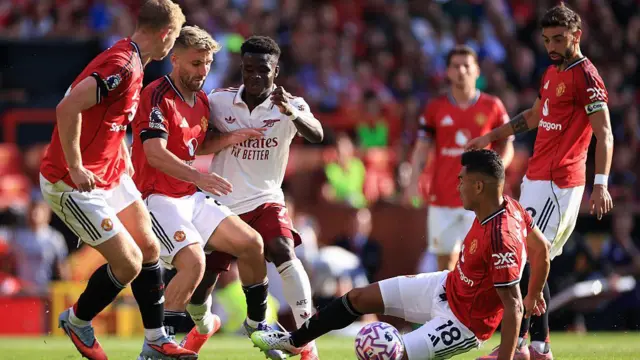 Manchester United's midfielders and defence try and close down Bukayo Saka