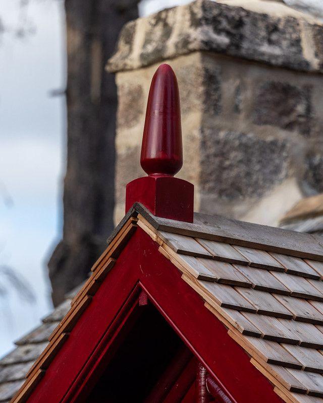 A porch roof with clay slates and a red border. 