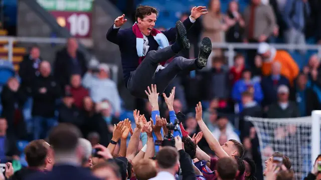 Burnley players celebrate promotion by throwing manager Scott Parker into the air 