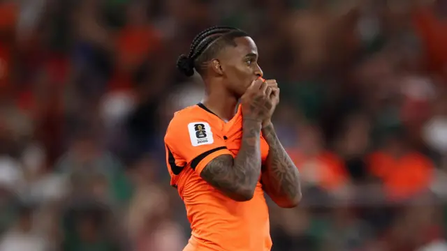 A photo of Crysencio Summerville, wearing his orange Netherlands kits, holding his shirt to his face after his penalty is saved against Morocco on Tuesday.