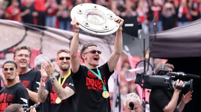 Florian Wirtz celebrates with the Deutsche Meisterschale trophy