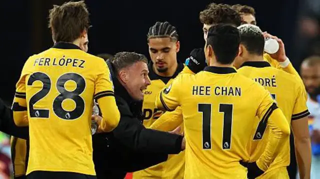 Rob Edwards speaks to several Wolves players in a huddle on the touchline during a match