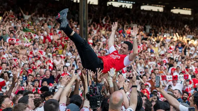 Arsenal players throw Mikel Arteta, Manager of Arsenal, in the air as they celebrate winning the Premier League