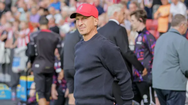 Gerhard Struber standing with his hands behind his back in the dugout 