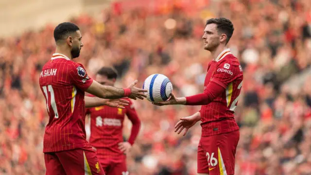 Andy Robertson hands Mohamed Salah the ball