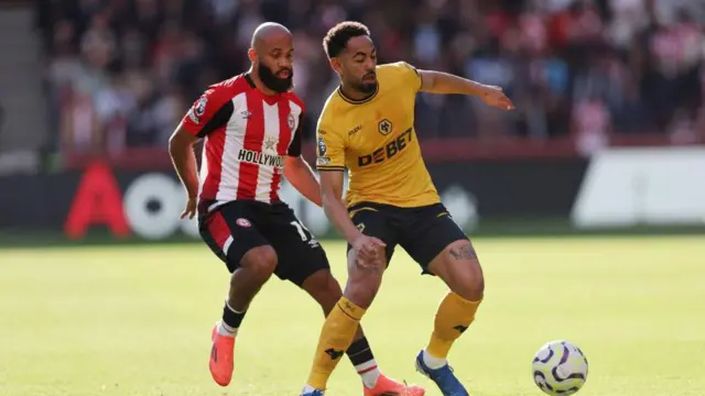 Matheus Cunha and Bryan Mbeumo challenge for the ball