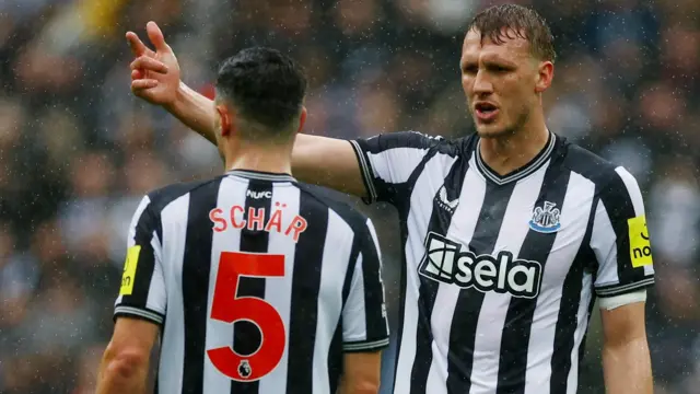 Newcastle defender Dan Burn speaks to Fabian Schar