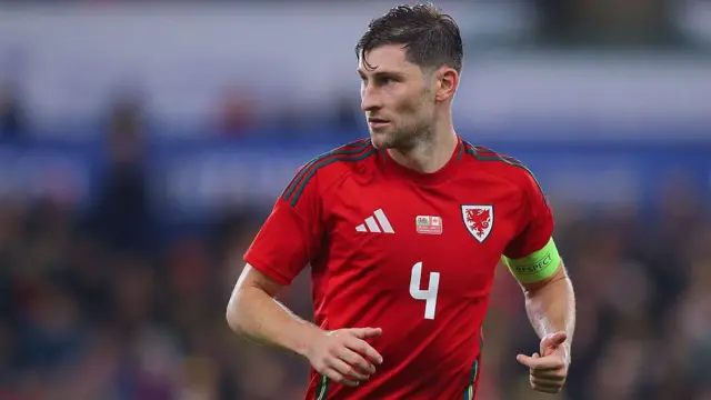 Ben Davies, wearing Wales' red home shirt, in action during a match