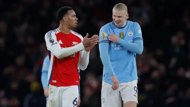Erling Haaland of Manchester City (right) shows off the Premier League winners badge on his shirt to Gabriel Magalhaes