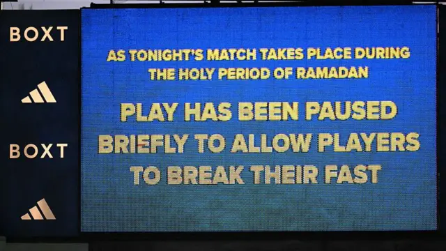 A big screen reads:
Play has been paused briefly to allow players to break their fast