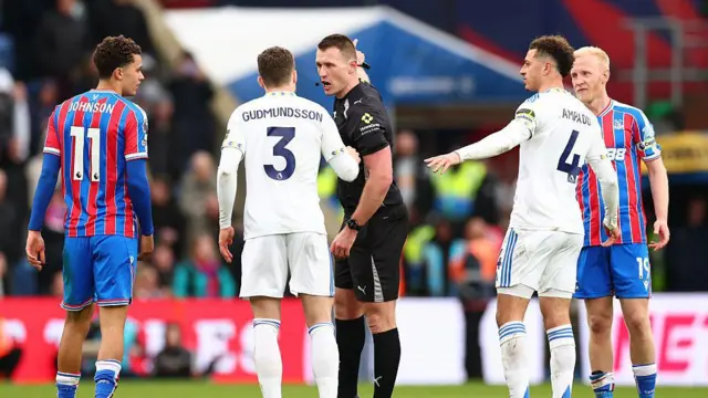 Referee Thomas Bramall informs Gabriel Gudmundsson of Leeds United to leave the field of play