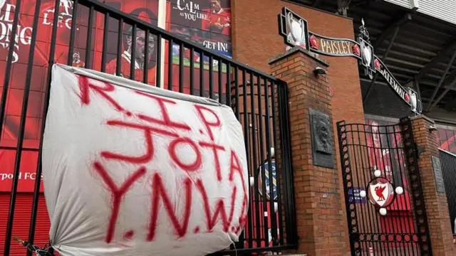 A flag reads R.I.P JOTA and hangs on the Paisley Gates at Anfield