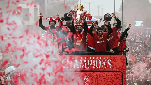 Liverpool players on top of a parade bus