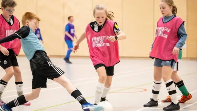 Kids play football wearing Newcastle United Foundation tops