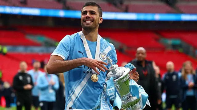 Rodri of Manchester City celebrates with the trophy at full-time following the Emirates FA Cup Final match between Chelsea and Manchester City