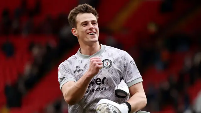 A close-up of Radek Vitek in his pink Bristol City goalkeeping kit clutching his hand in a fist in celebration