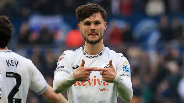 Swansea forward Liam Cullen celebrates scoring with fingers pointing together in front of him
